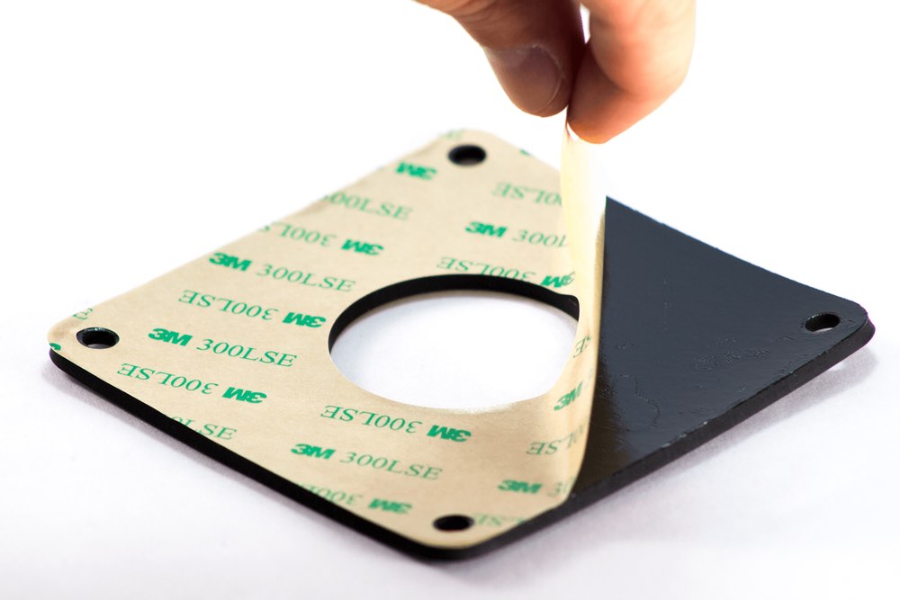 Hand holding a sheet of Poron gasket material.